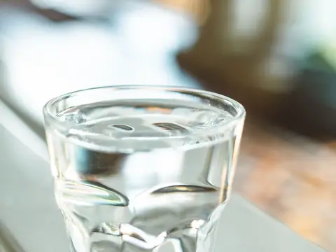 A clear glass of water on a sunny windowsill