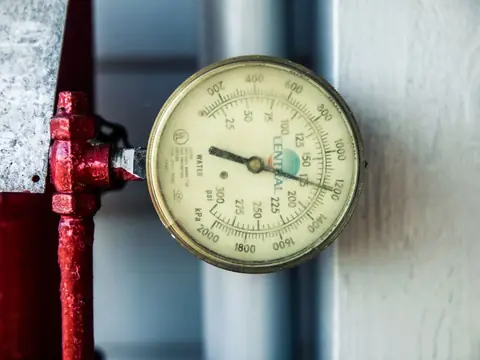 A pressure gauge fitted to a red pipe