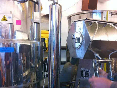 A stainless steel filter housing with a pressure gauge on top