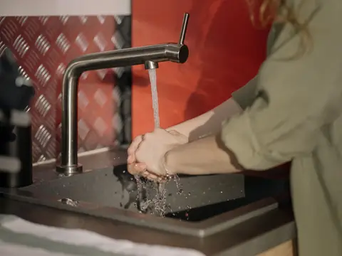 Water running from a kitchen tap over a pair of hands