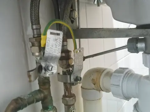 Supply lines, valves and drain pipes behind a sink